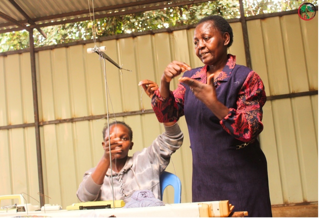 Rosemary training participants on sewing machine use.